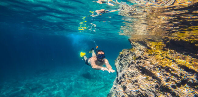 Underwater photo of a men snorkeling by the reef